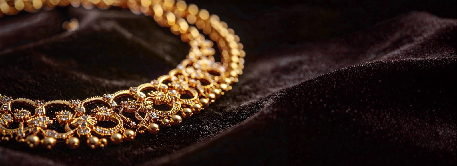 Gold and diamond collar necklace on dark velvet — Ramanand Jewellers